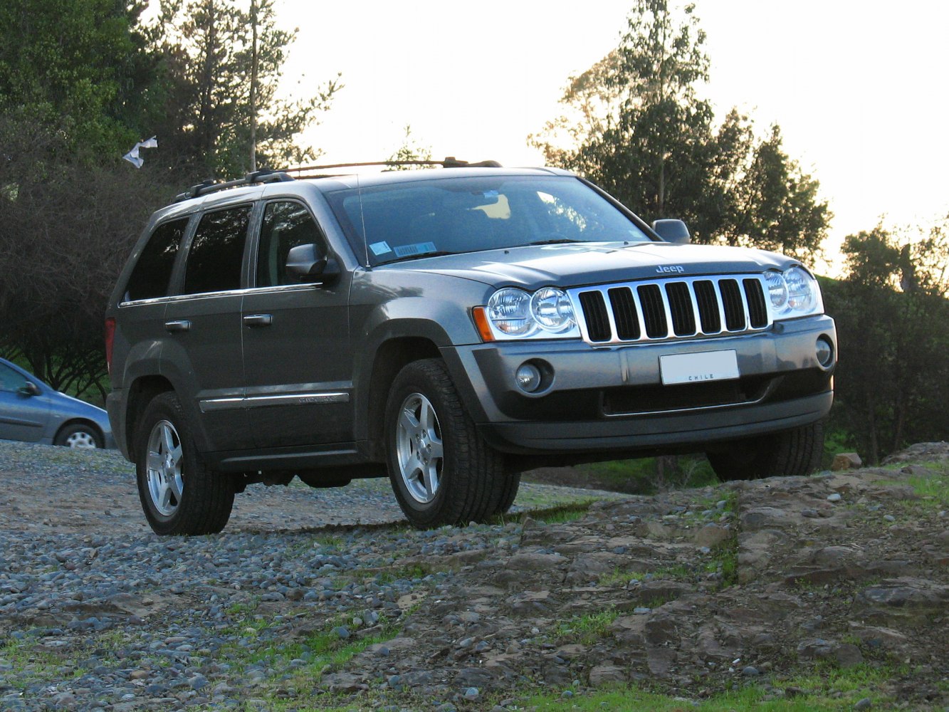 SUV with distinctive seven-slot grille and off-road on rocky terrain