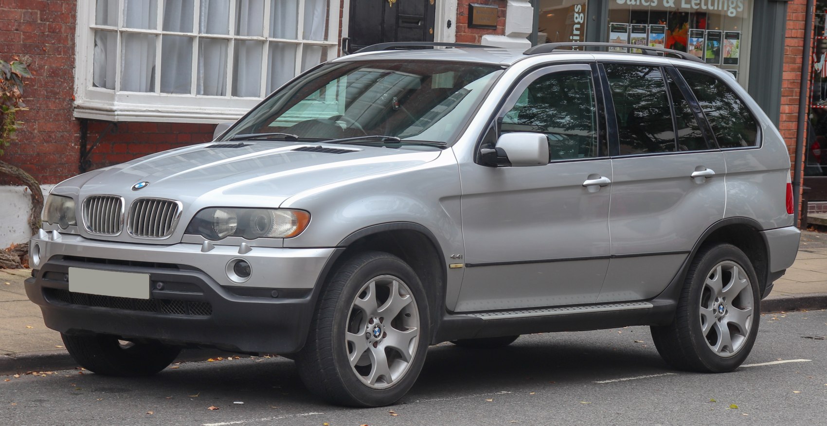 Silver SUV with kidney grille and alloy wheels, front-side urban view
