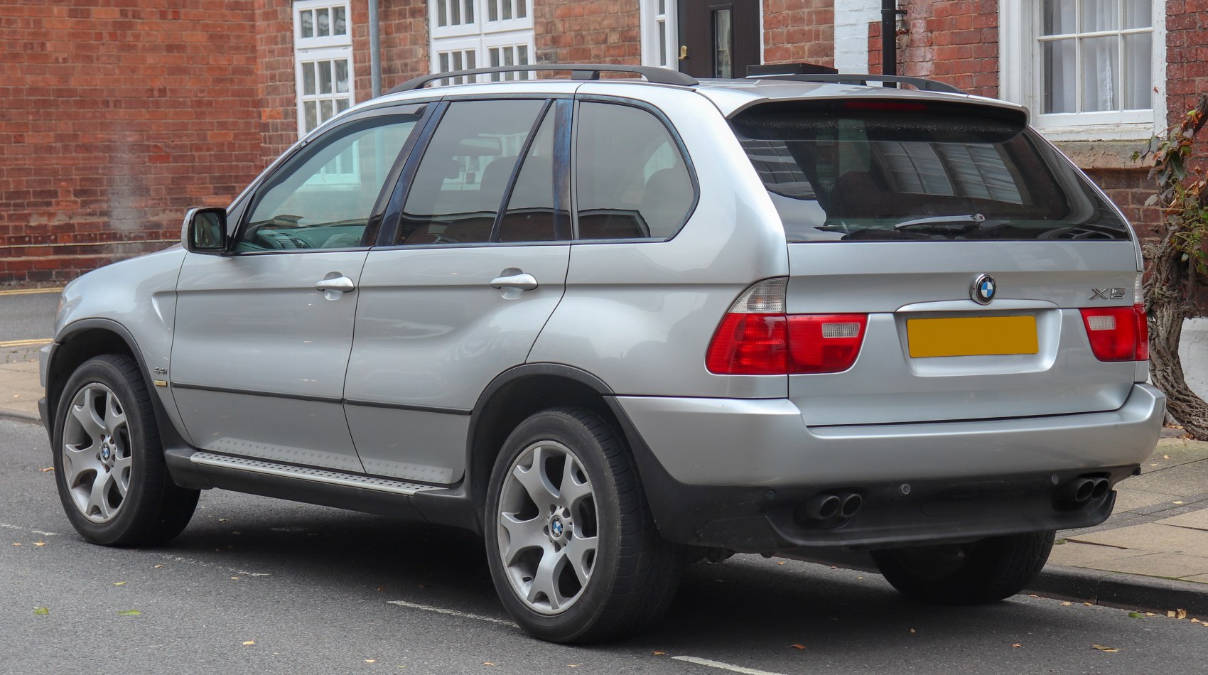 Rear-side view of silver SUV with alloy wheels and dual exhaust