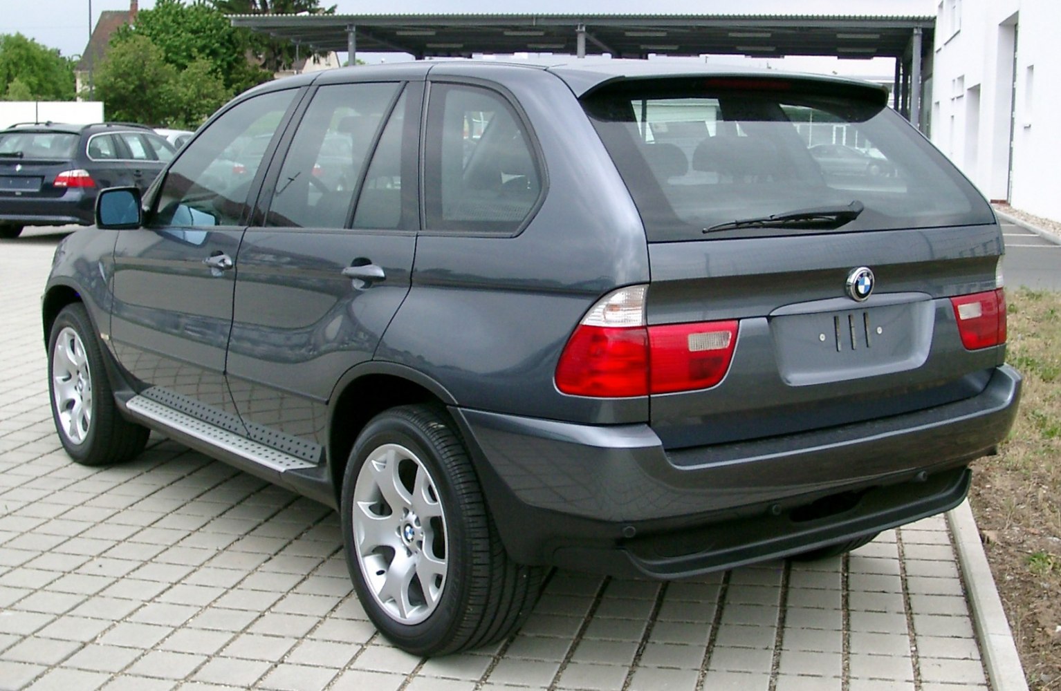 Rear side view showing alloy wheels and roof spoiler.