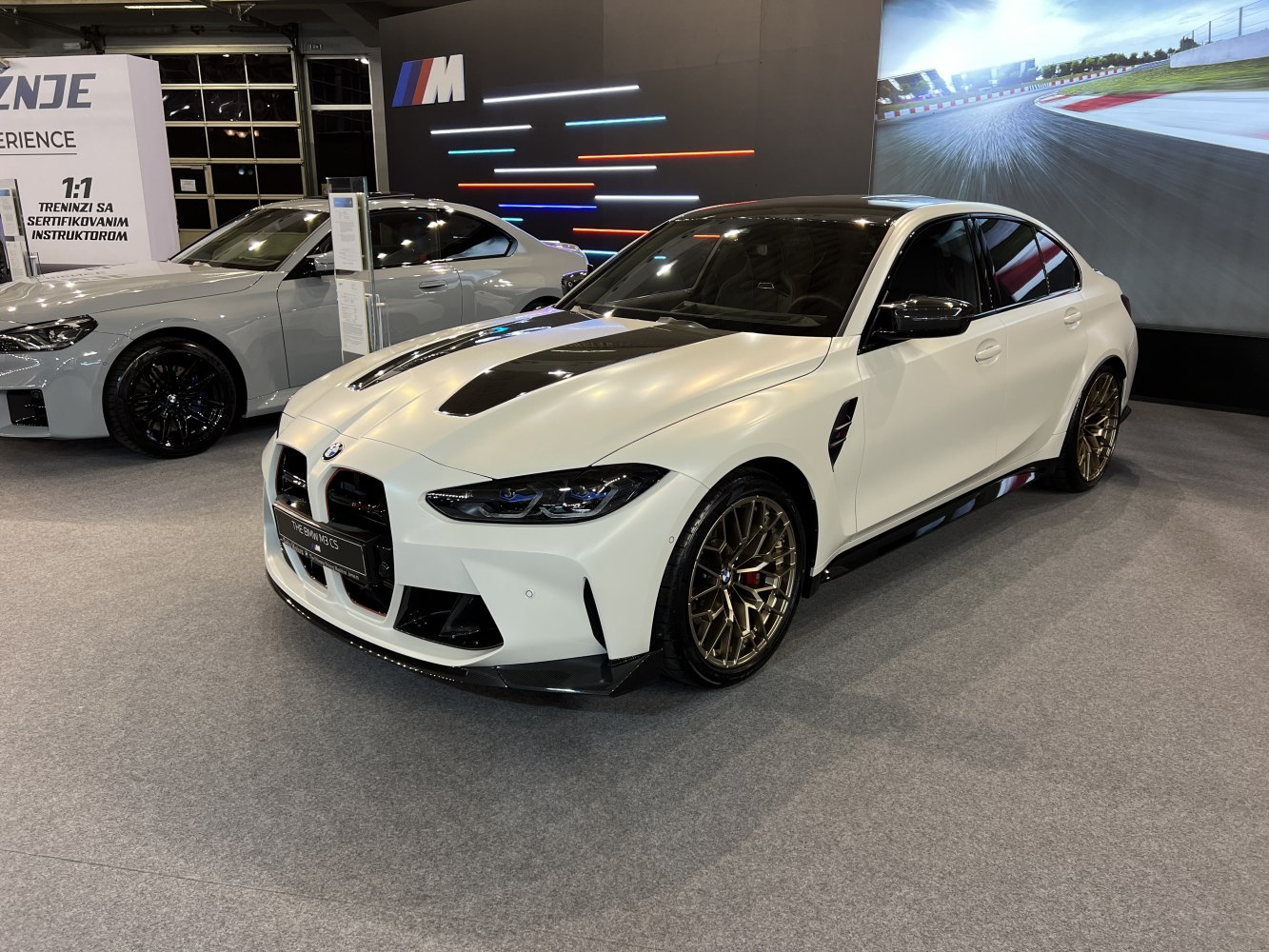 White sports sedan with carbon fiber hood and gold wheels