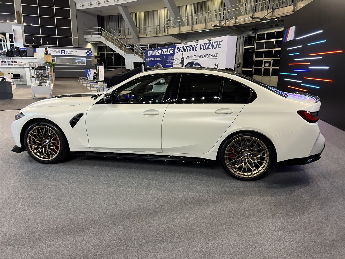 Side profile of a sedan with bronze multi-spoke alloy wheels.