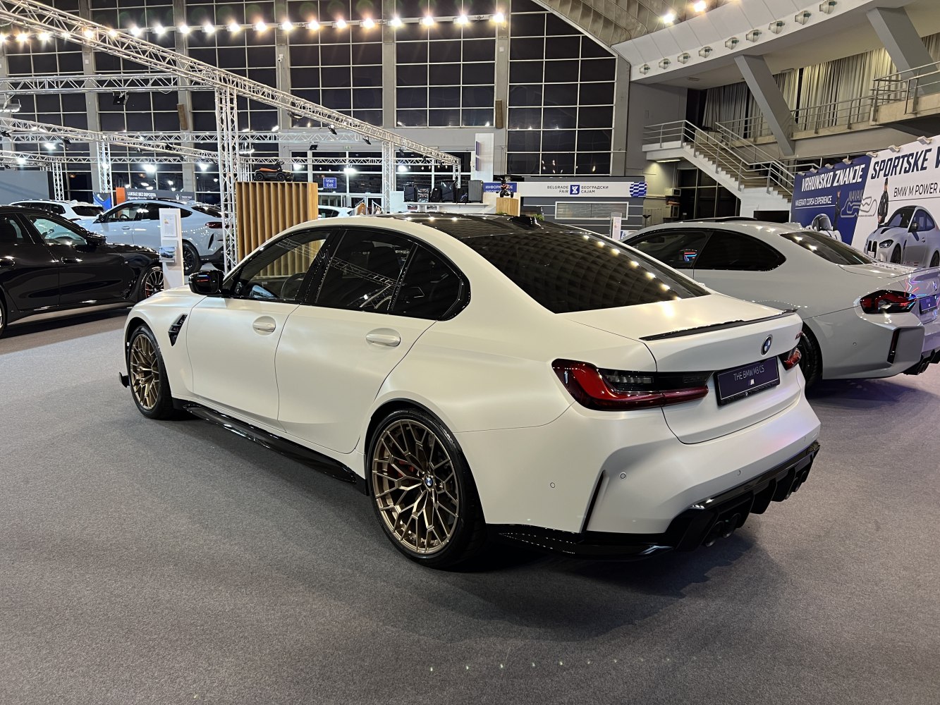 Rear view of white sedan with bronze wheels and black diffuser