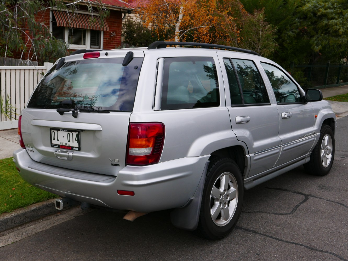 Silver SUV rear with roof rack and V8 badge