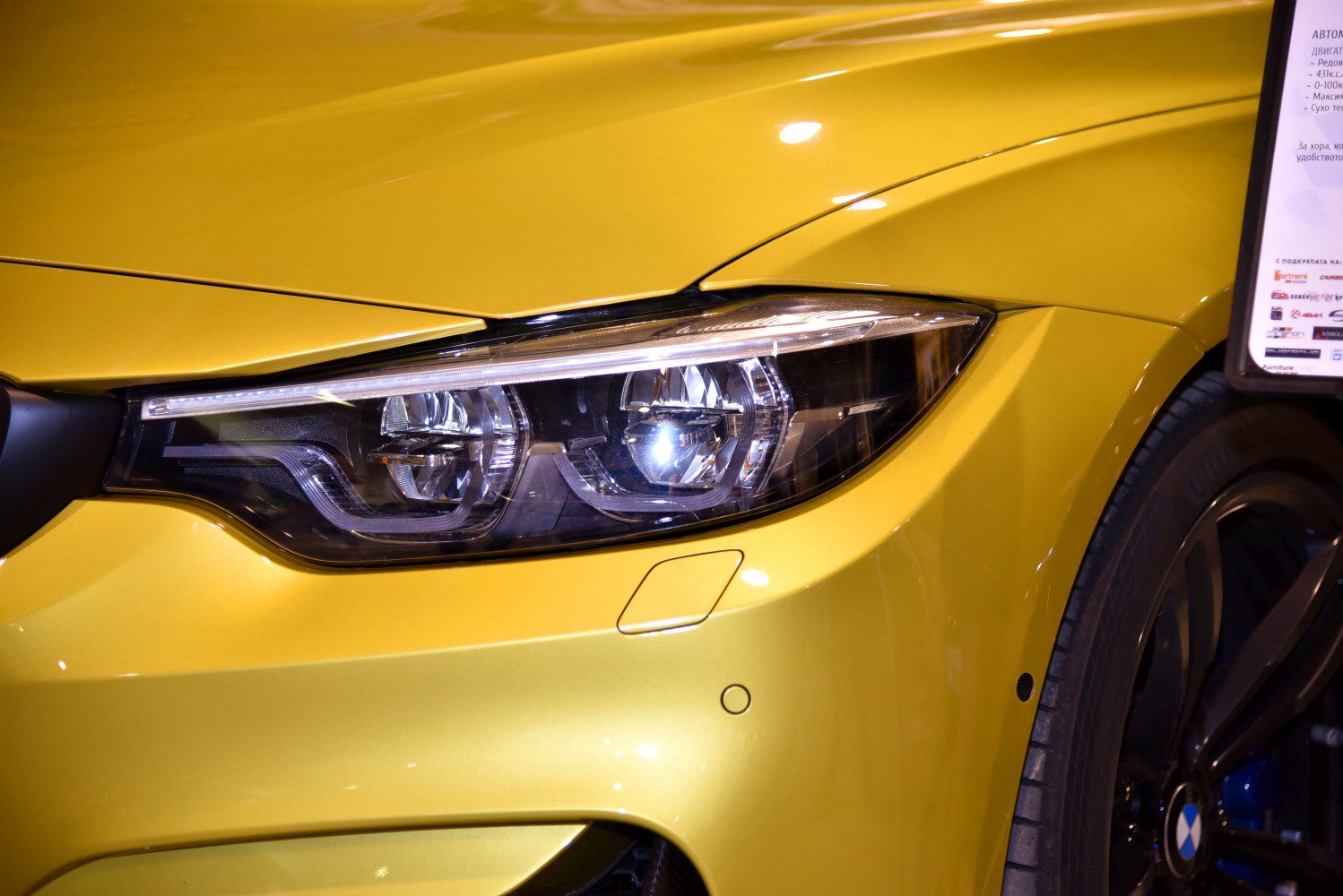 Close-up of BMW-style headlight and front fender in yellow
