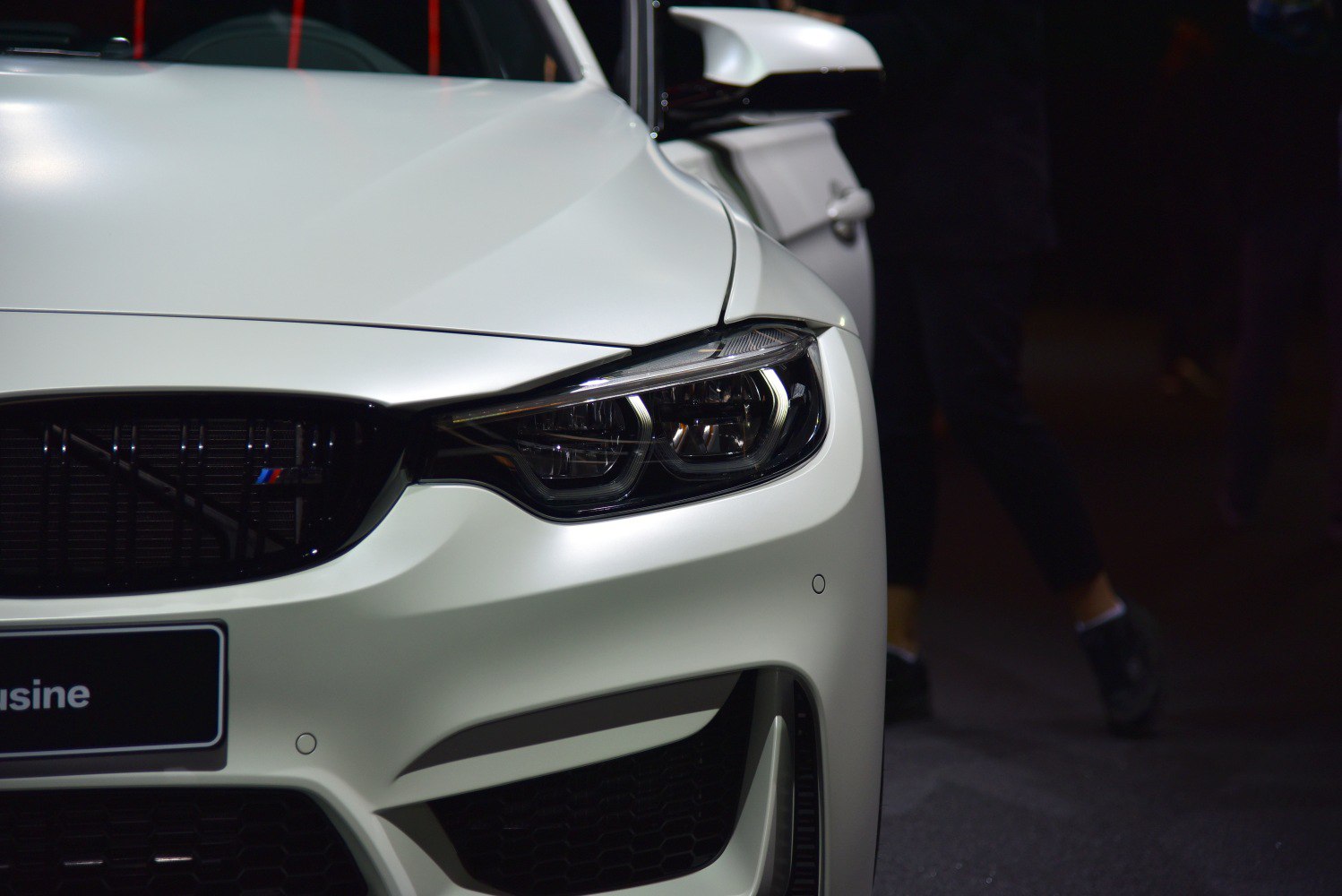 Close-up of headlight and front grille with aggressive styling