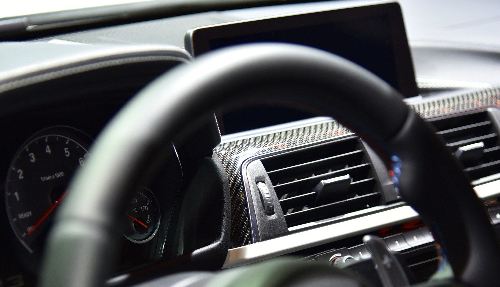 Dashboard with carbon fiber trim and air vent in car interior