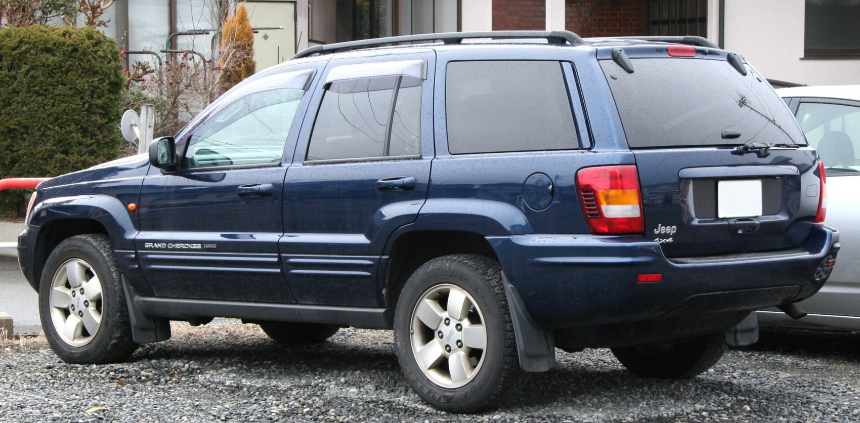 Side and rear view of mid-2000s SUV with tinted windows and alloy wheels