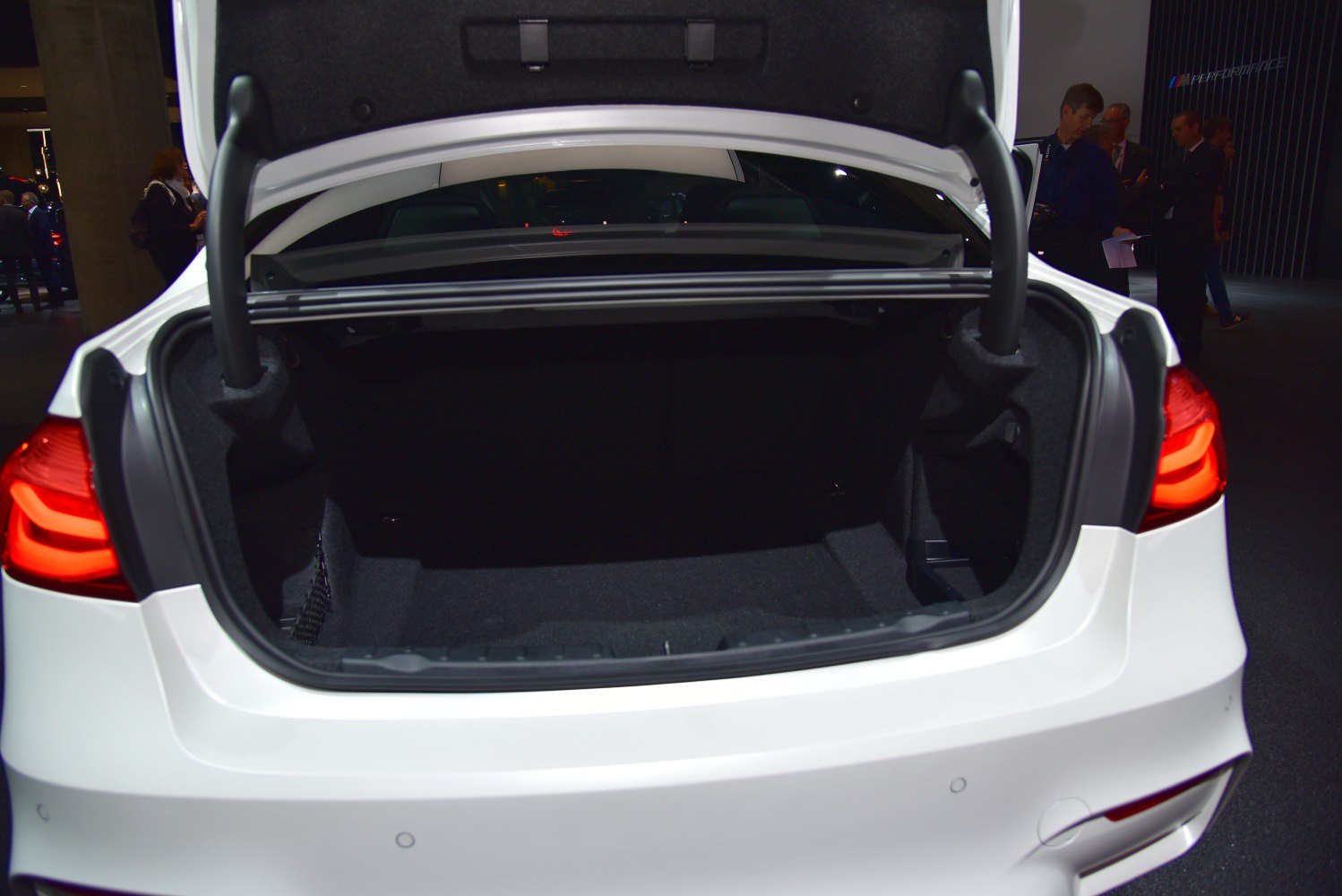 Open rear trunk with visible spacious cargo area and trunk hinges