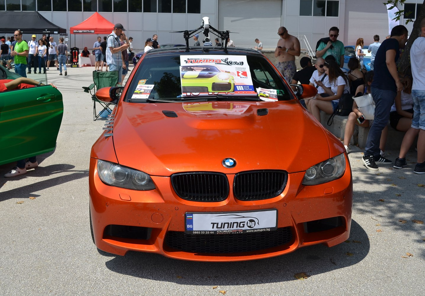 Front view of orange sports coupe with hood vents and tuning decals