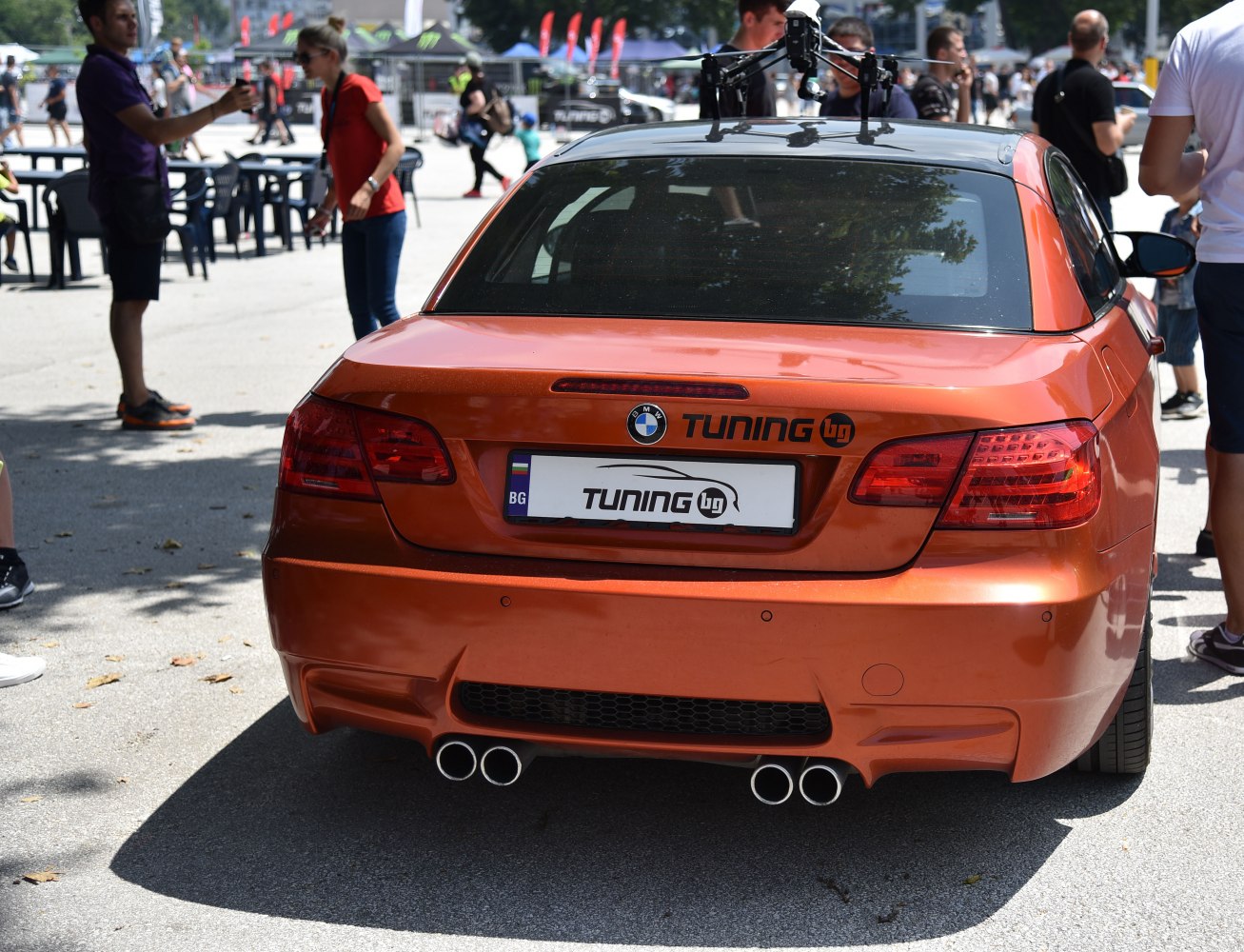 Rear view of orange convertible with quad exhaust and tinted rear window