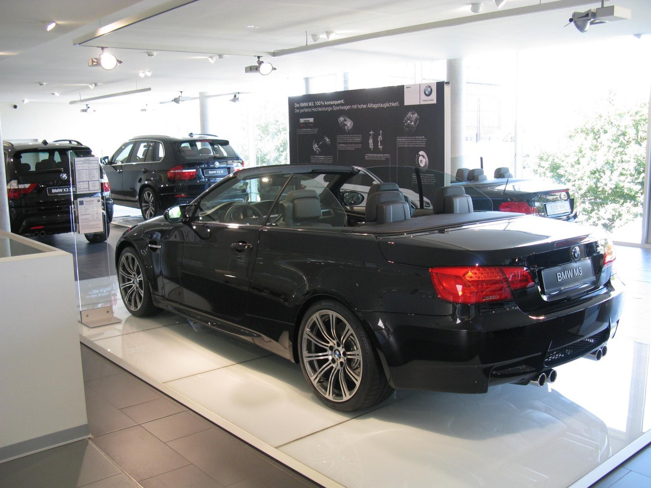 Black BMW convertible with rear and side view, detailed wheels and dual exhaust