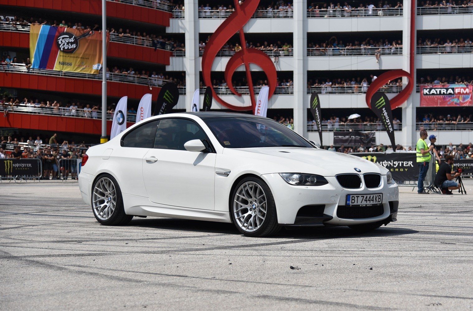 White sporty coupe with aggressive front grille and multi-spoke wheels