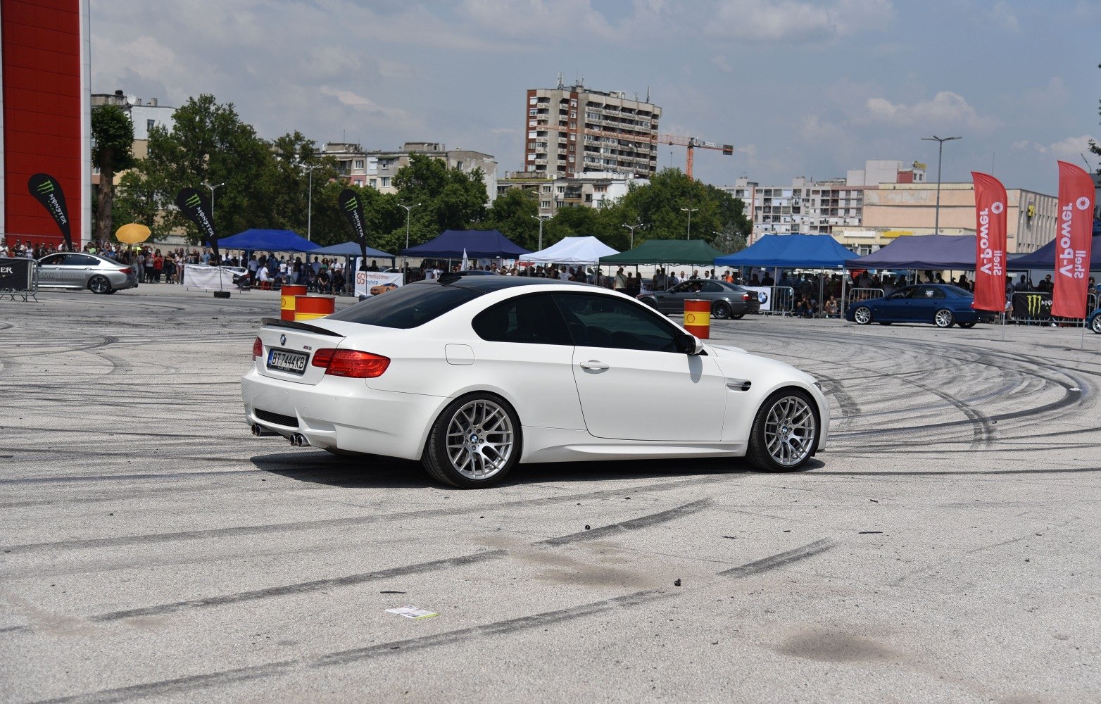 White coupe rear side with tinted windows and aftermarket wheels