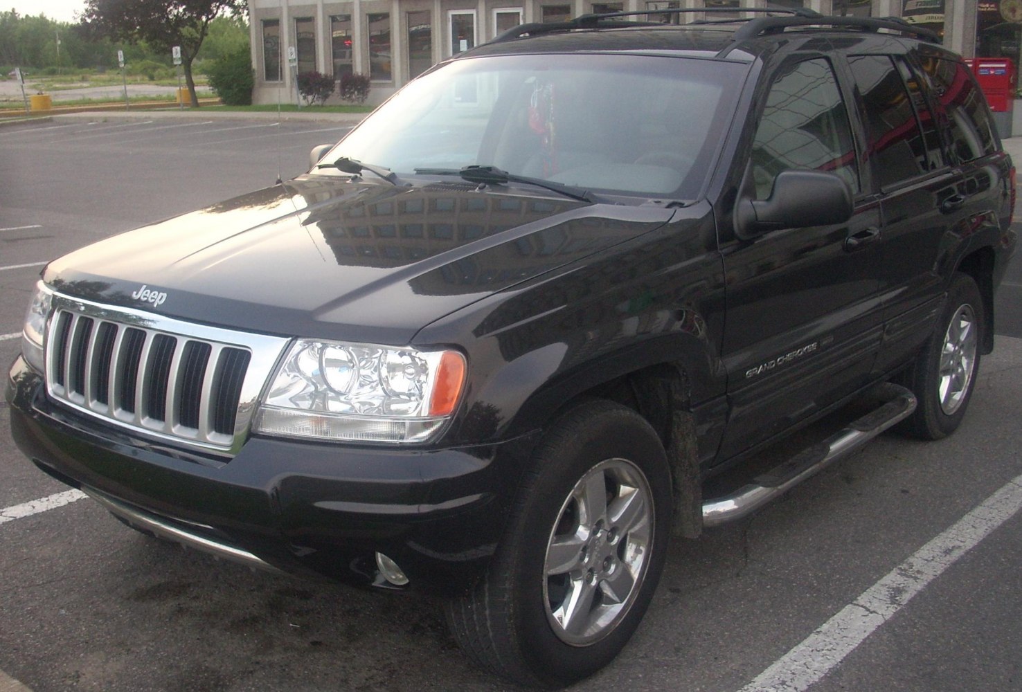 Black SUV with seven-slot grille, dual headlights, alloy wheels, side step