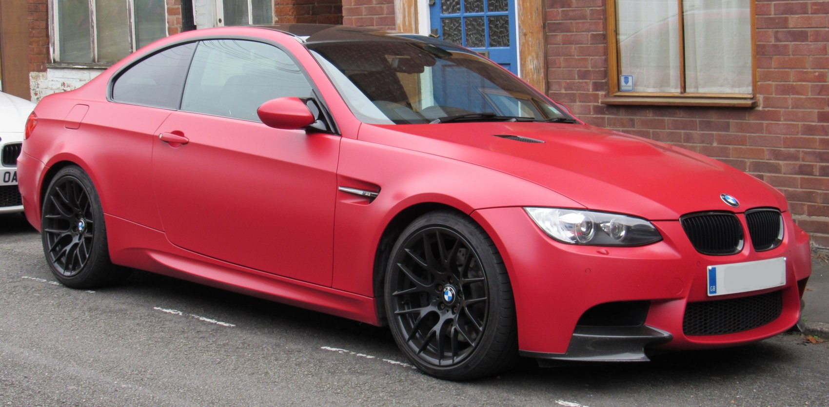 Matte red coupe with black wheels and carbon fiber splitter