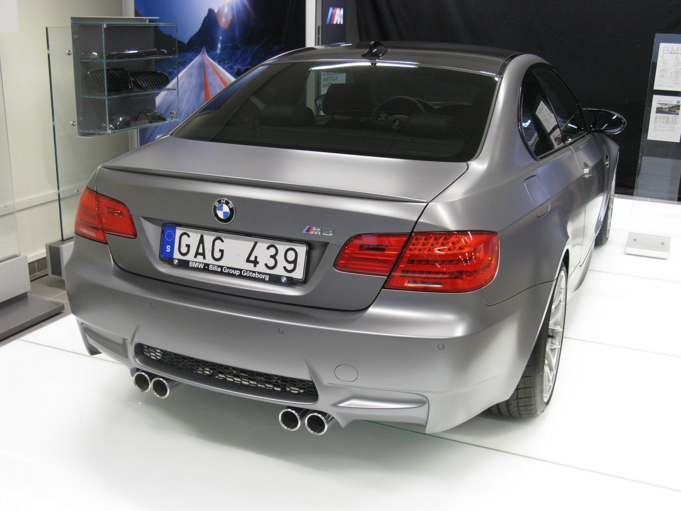 Rear view of a matte grey coupe with quad exhaust and LED taillights