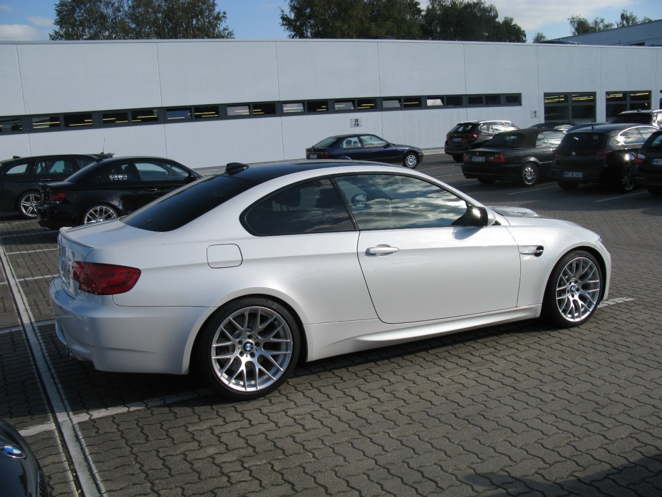 White coupe with sporty design and multi-spoke alloy wheels side view