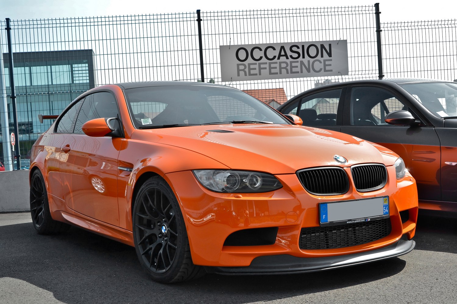 Orange sports coupe with black multi-spoke wheels and aggressive front splitter