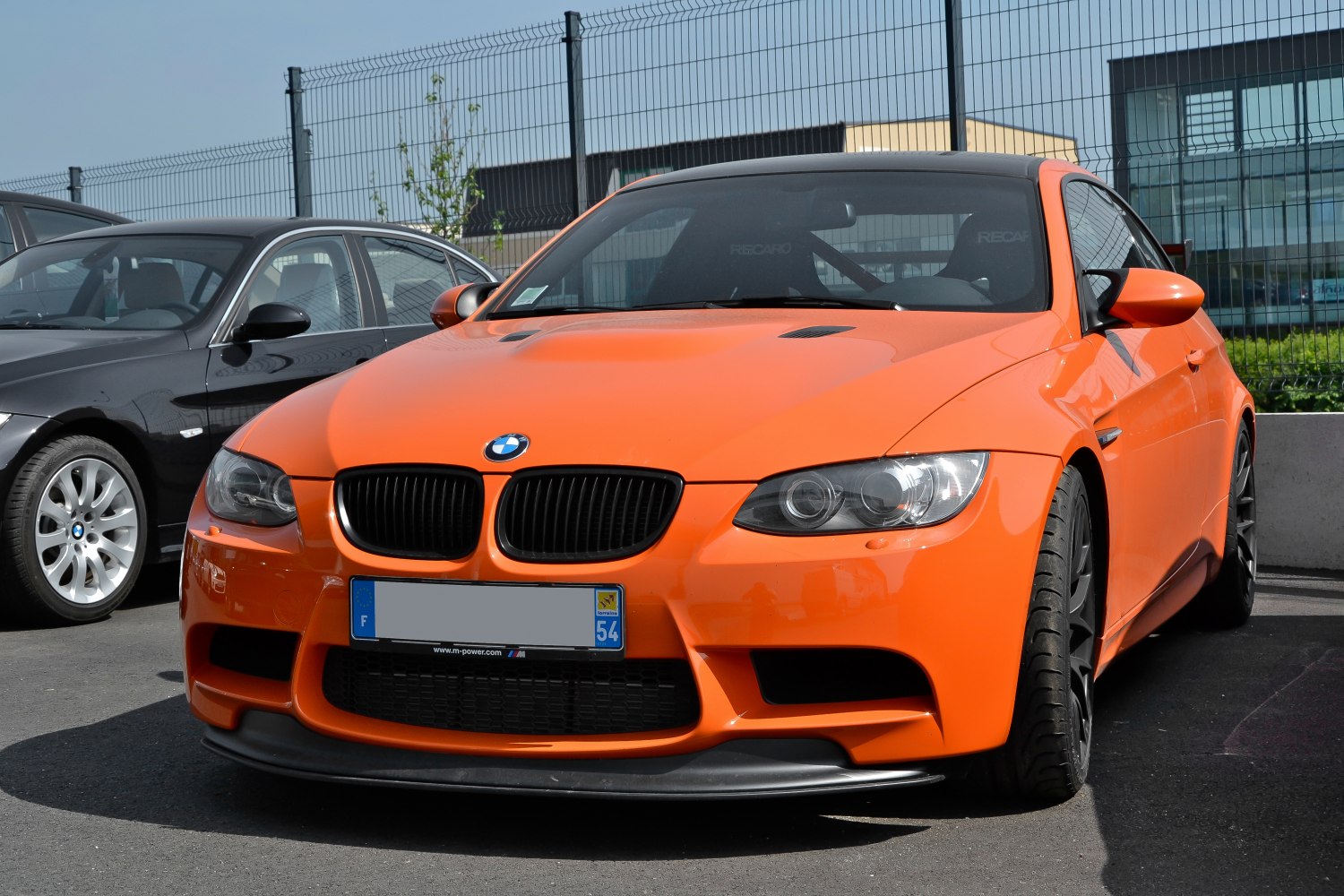 Orange sports coupe with aggressive front bumper and black kidney grilles