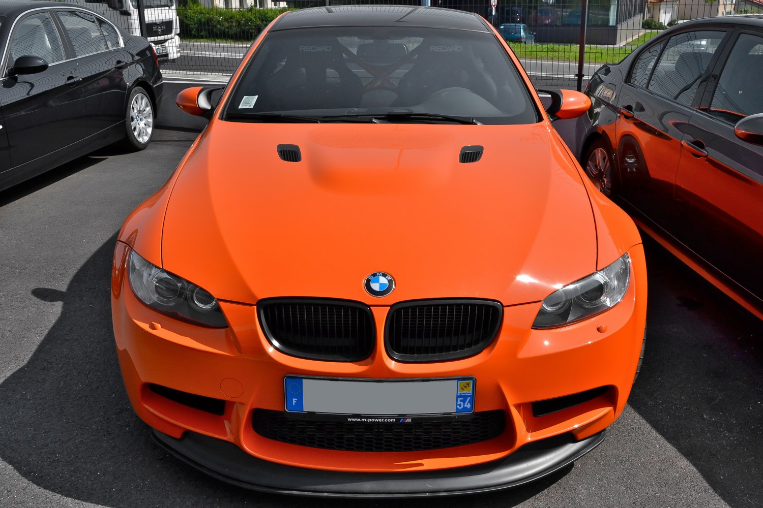 Bright orange coupe front with ventilated hood and kidney grille