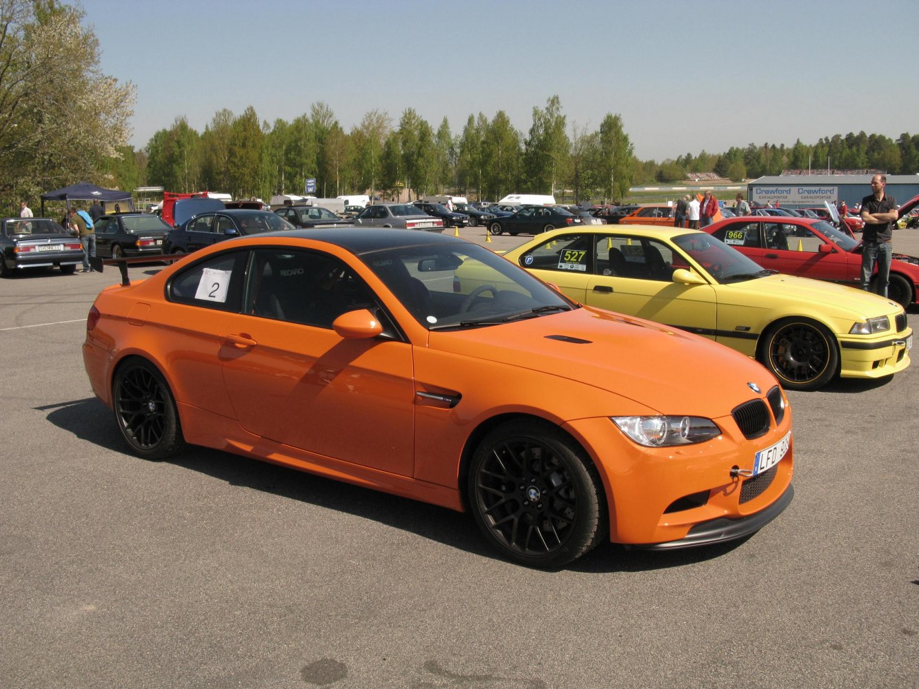 Orange sports coupe with black alloy wheels and rear spoiler