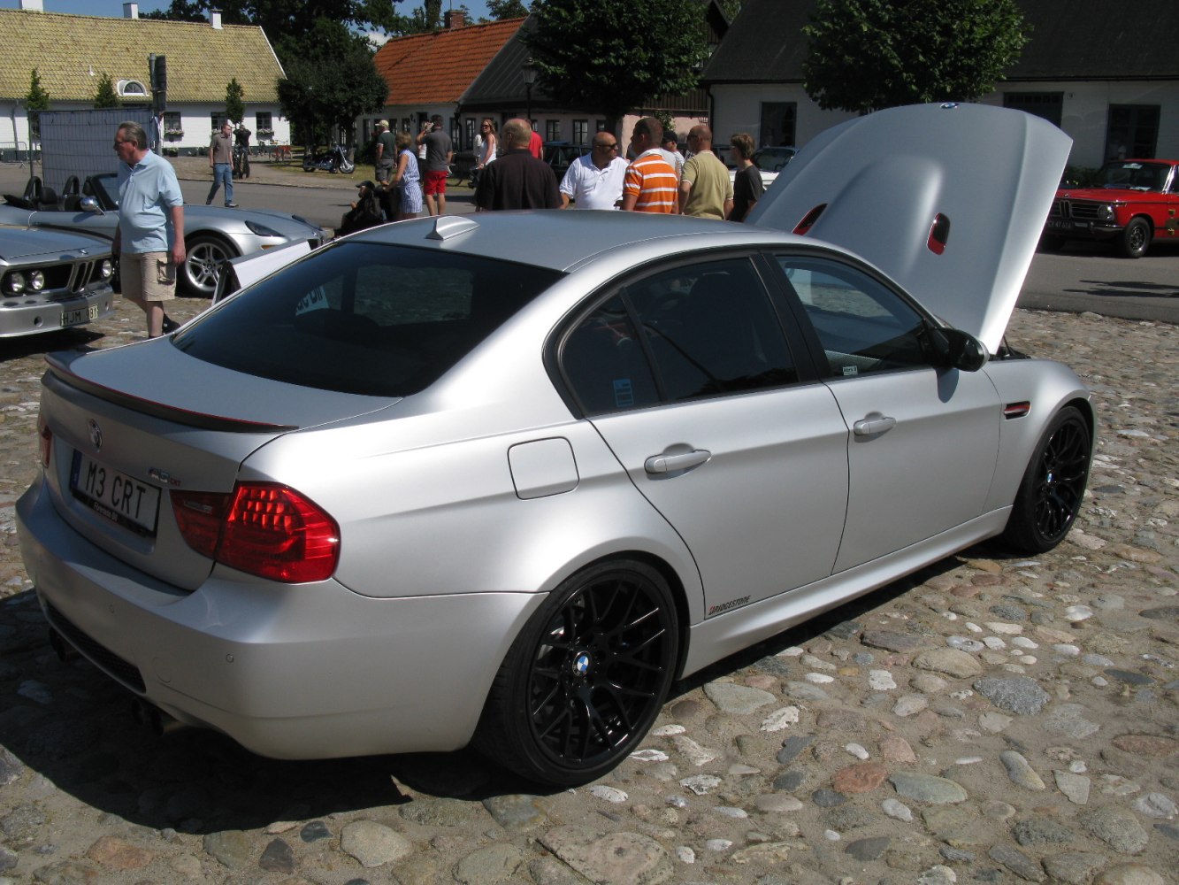 Silver sedan with black alloy wheels and open hood