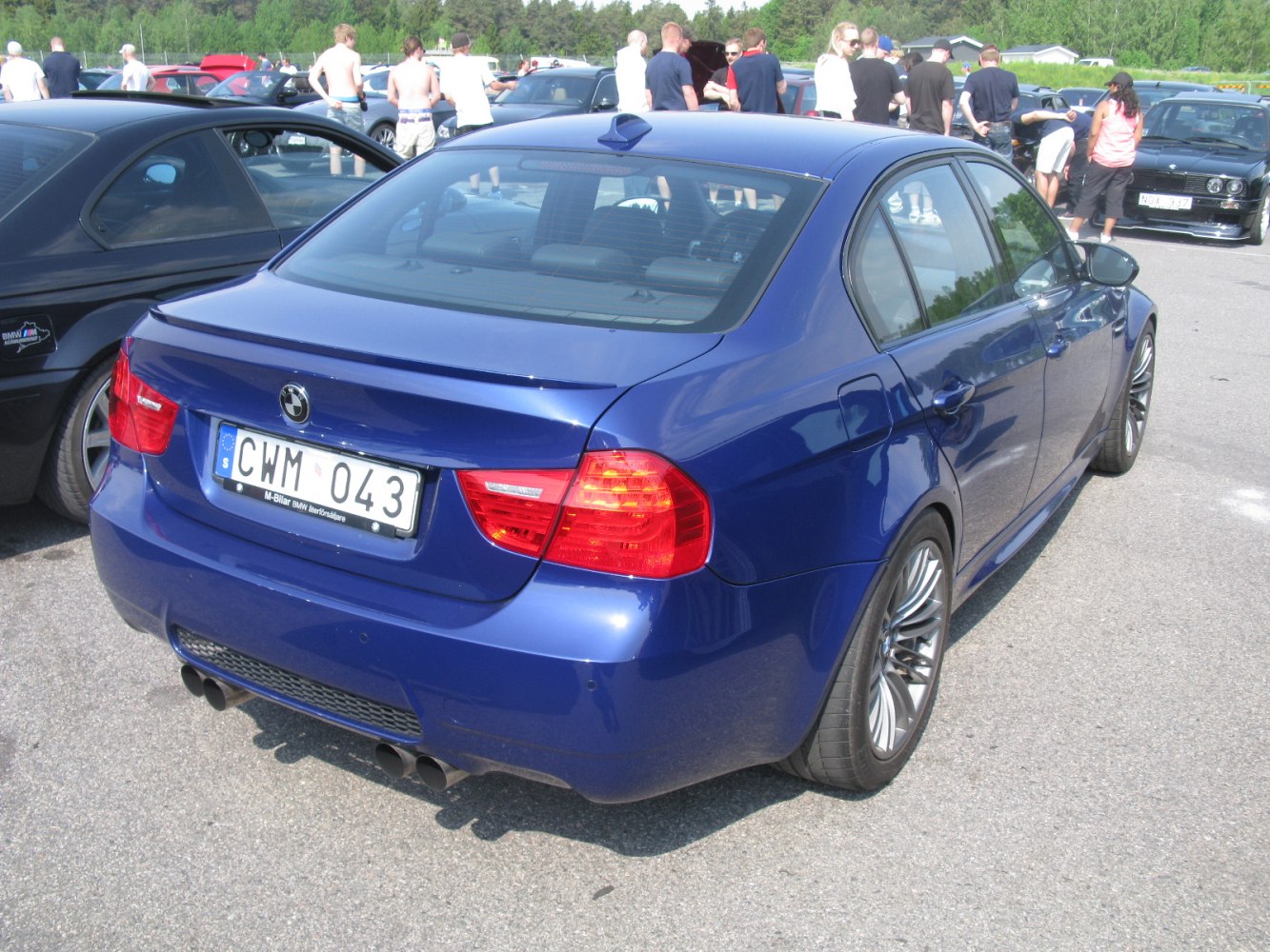 Rear view with quad exhaust, rear spoiler, and alloy wheels