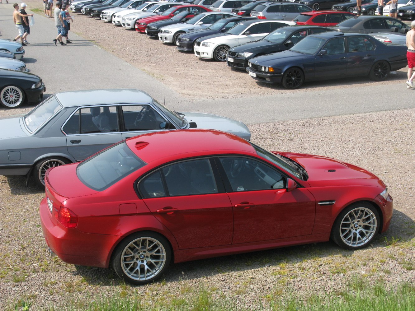 Red BMW M3 E90 LCI sedan with alloy wheels parked outdoors