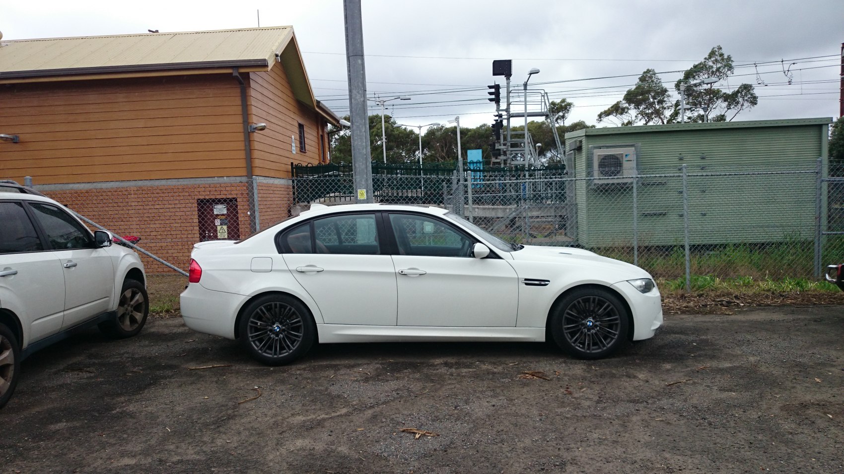 White BMW sedan side view with black alloy wheels