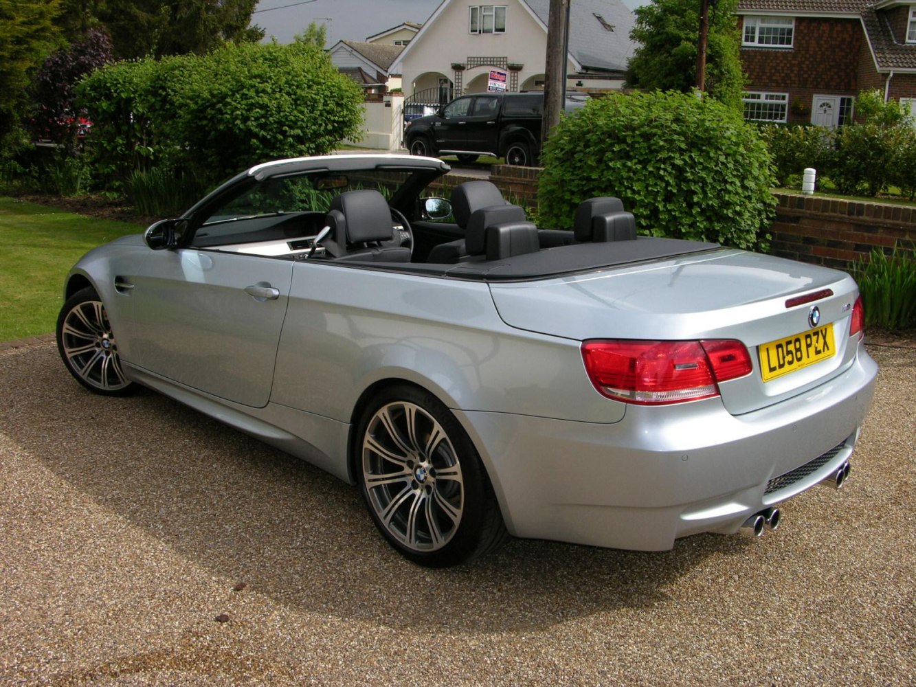 Rear-side view of silver convertible with alloy wheels and open roof