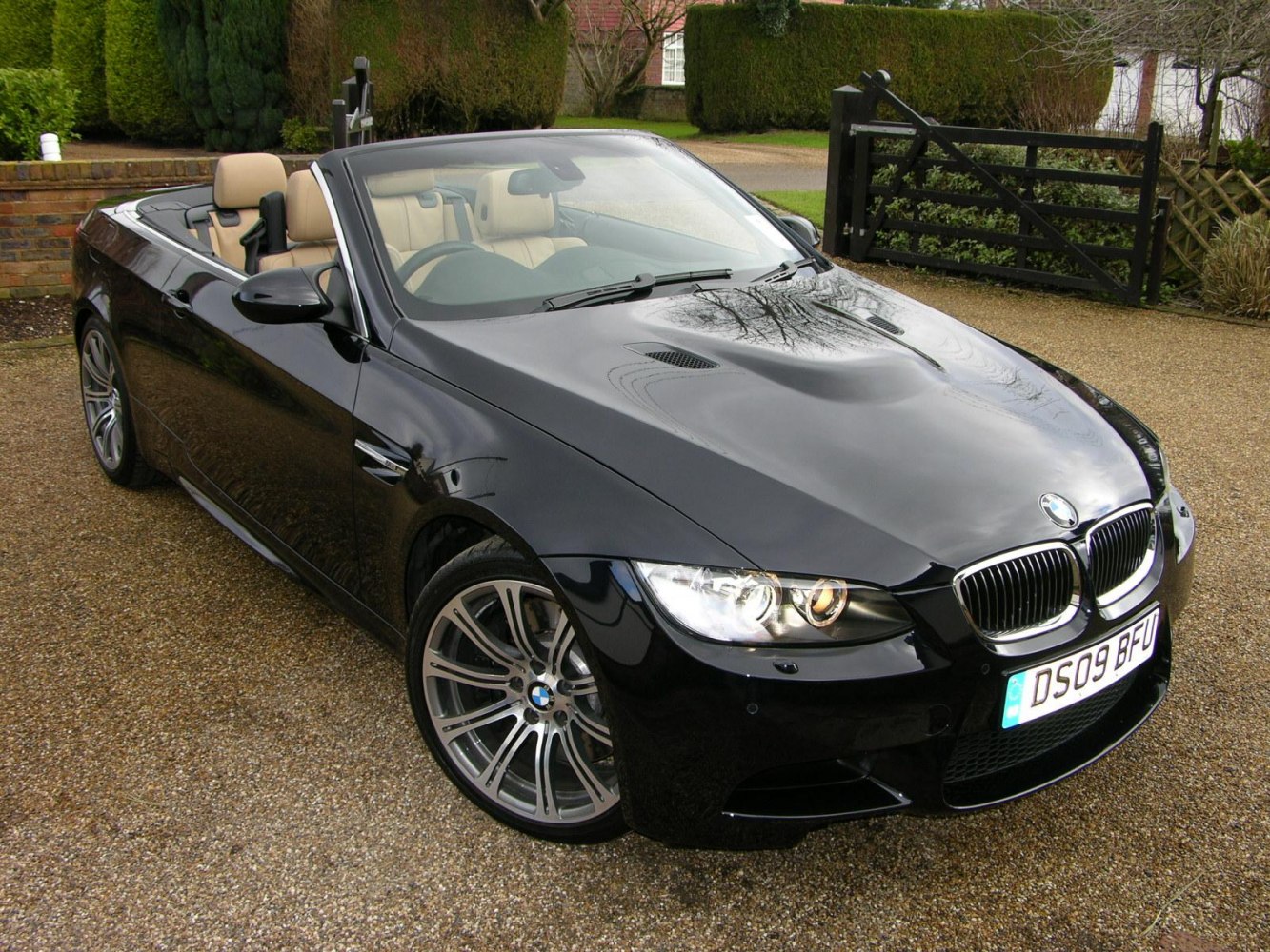 Black convertible with sporty hood vents and signature alloy wheels.