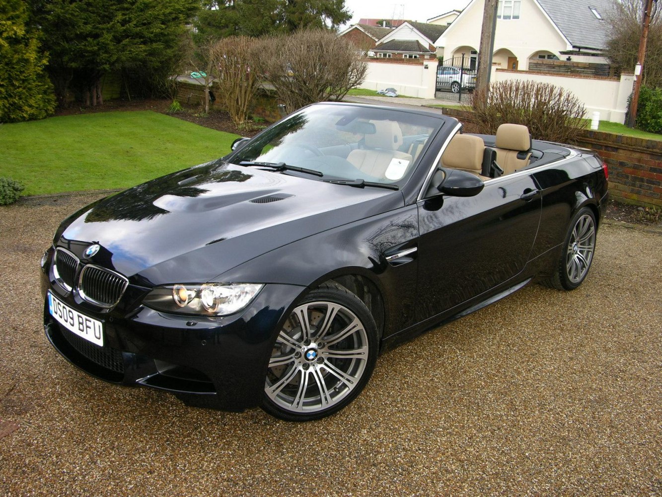 Front side view of black convertible with open roof and alloy wheels