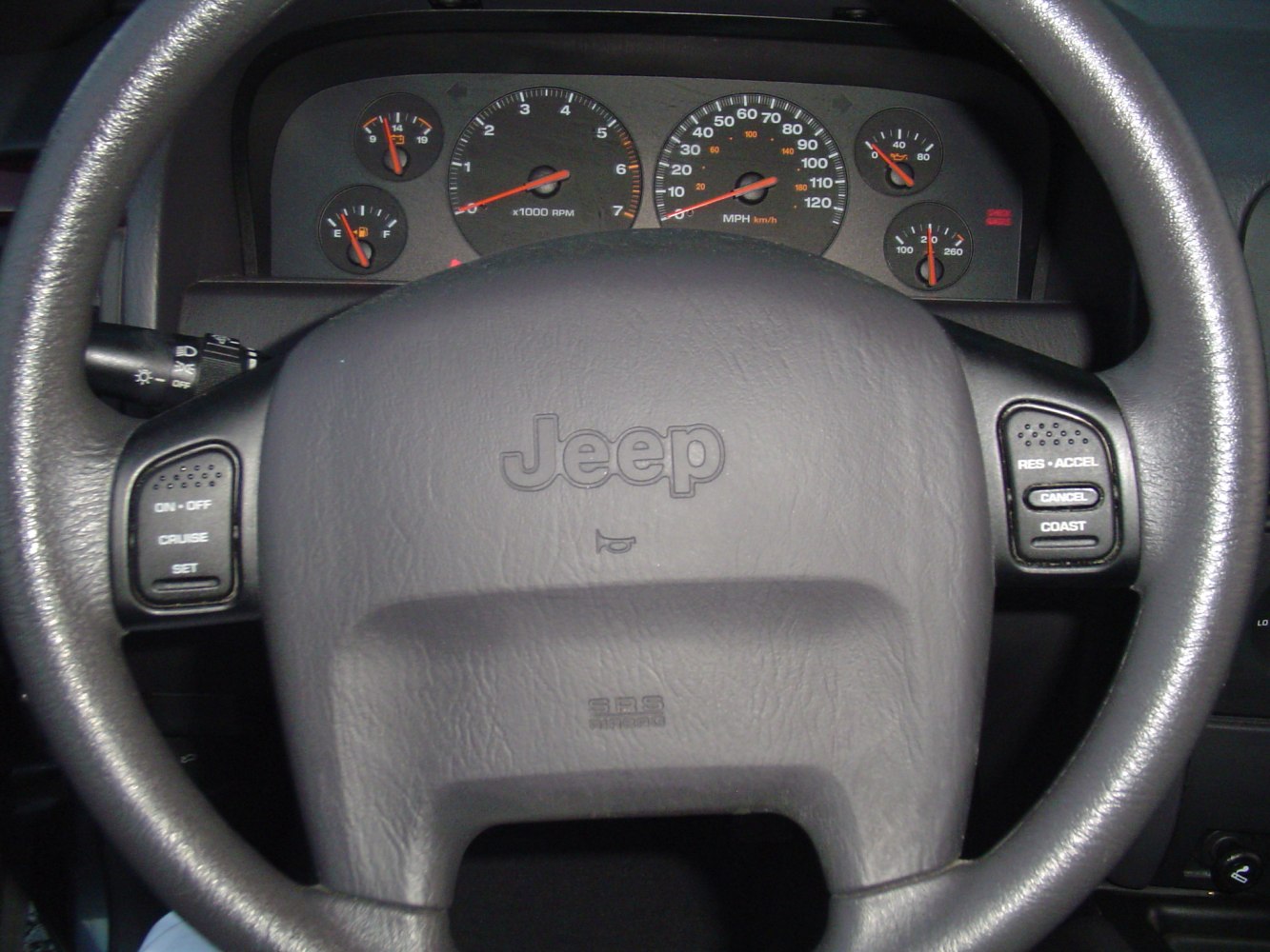 Steering wheel with cruise control buttons and classic instrument cluster gauges