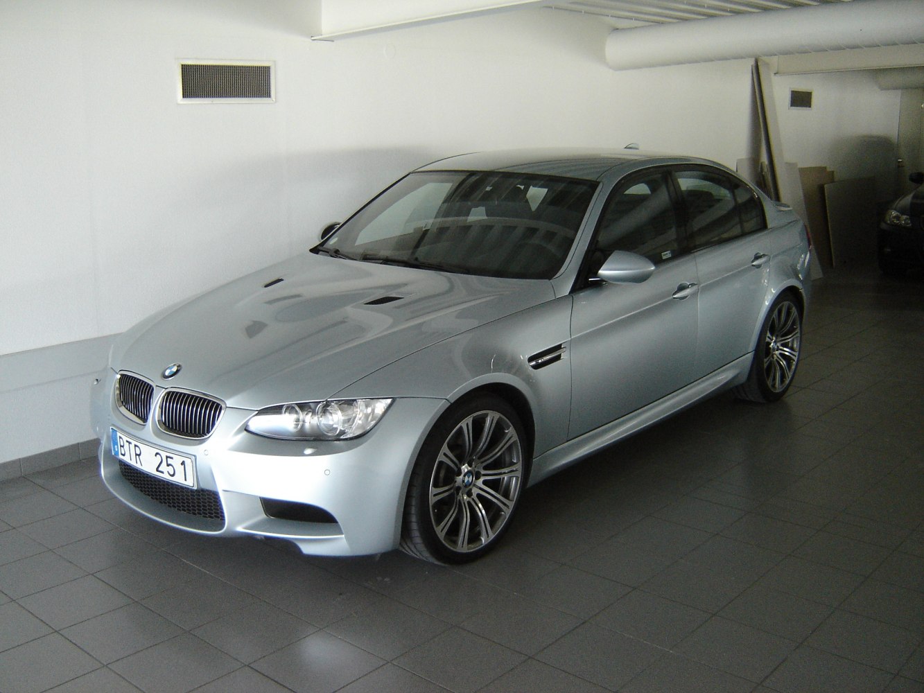 Silver sedan with aggressive front grille, air vents, and sporty alloy wheels