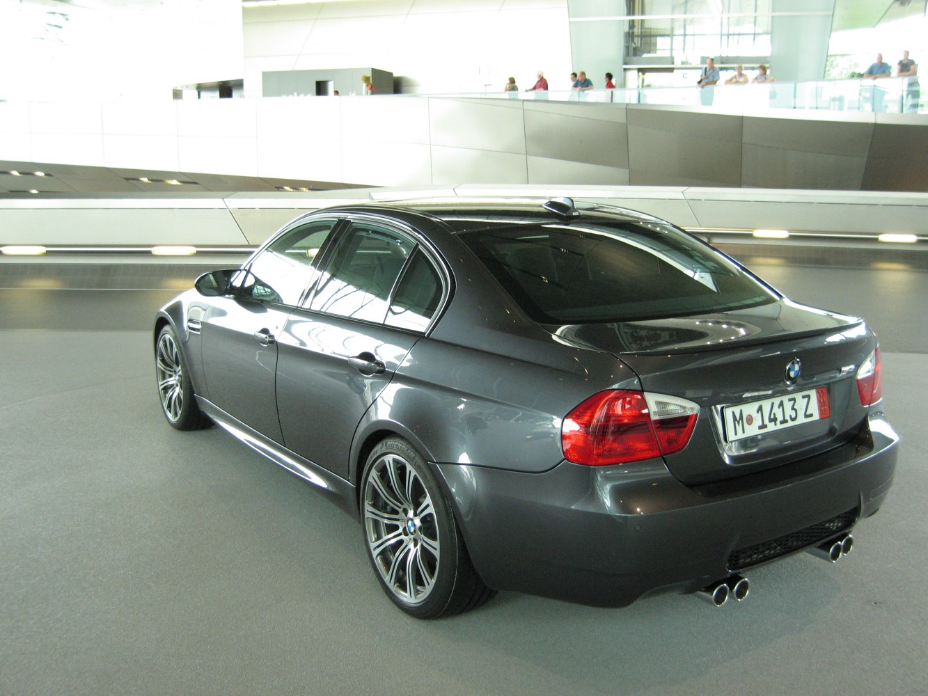 Rear and side view of sedan with quad exhaust and alloy wheels