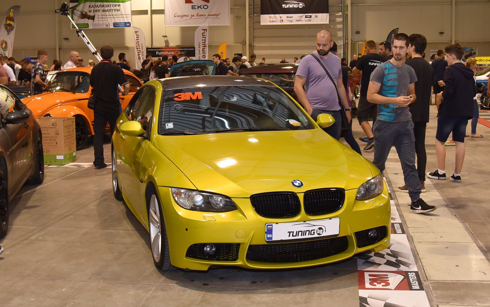 Bright yellow coupe front with black kidney grille and dual round headlights