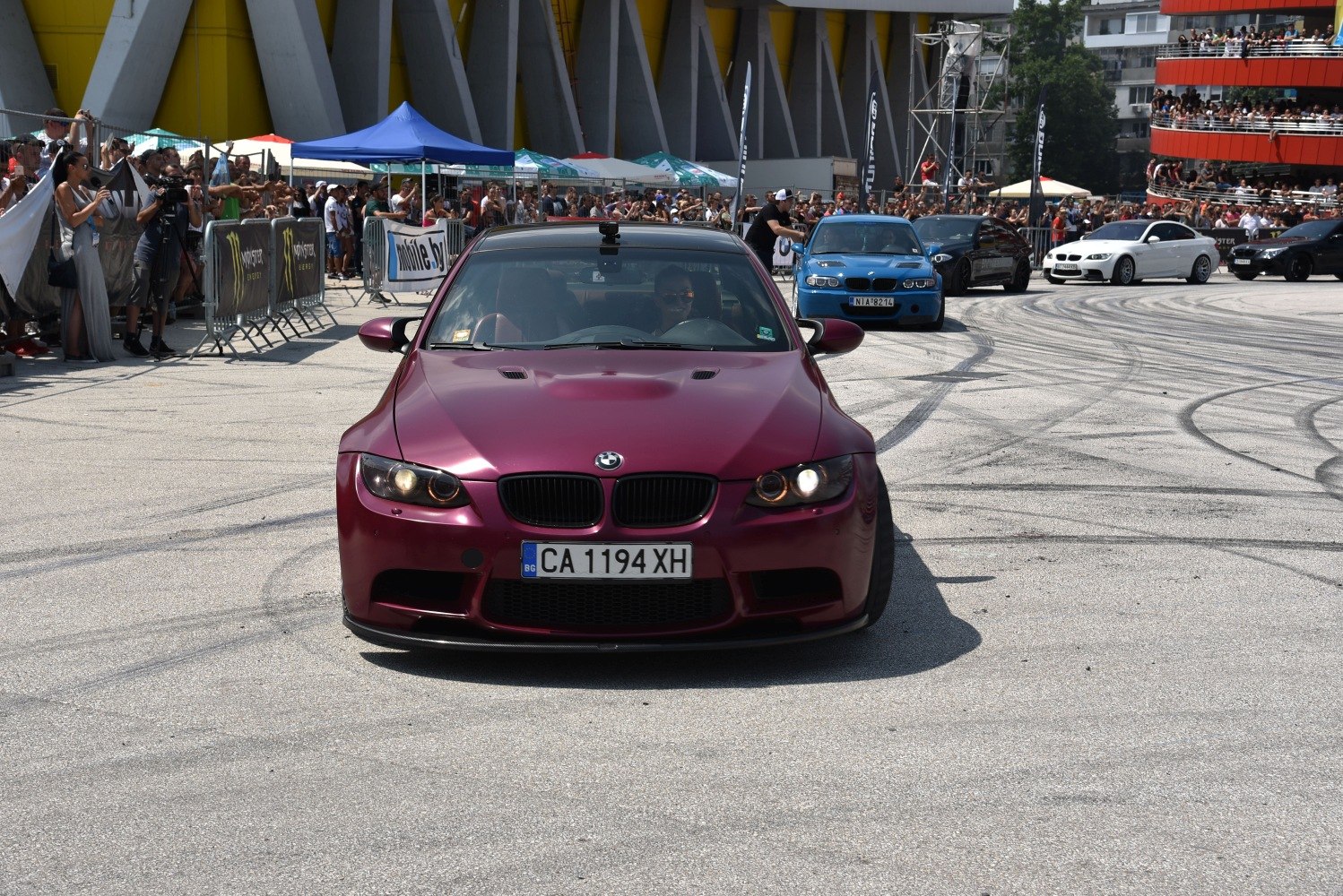 Front view of custom BMW M3 Coupe with hood vents and sporty grille at car meet.
