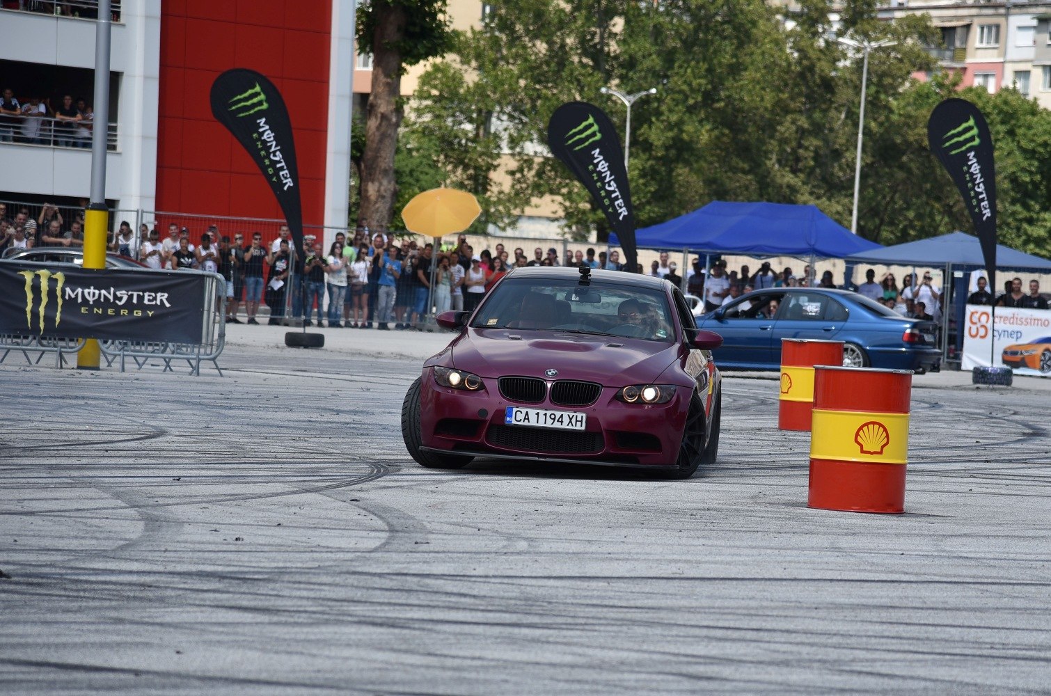 Front view of a BMW E92 drifting with tire marks and barrels.
