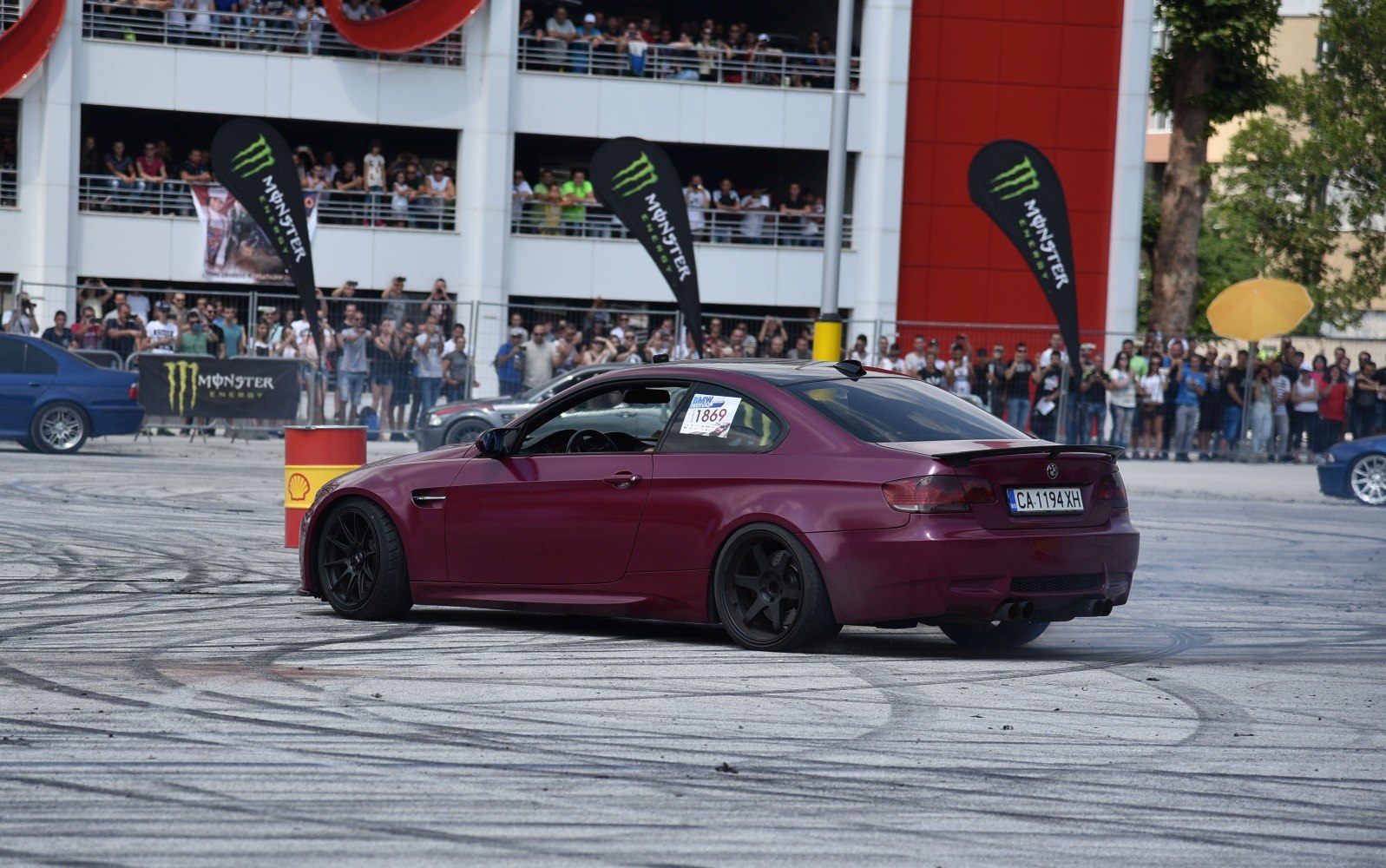 Sporty coupe drifting with black wheels and rear spoiler