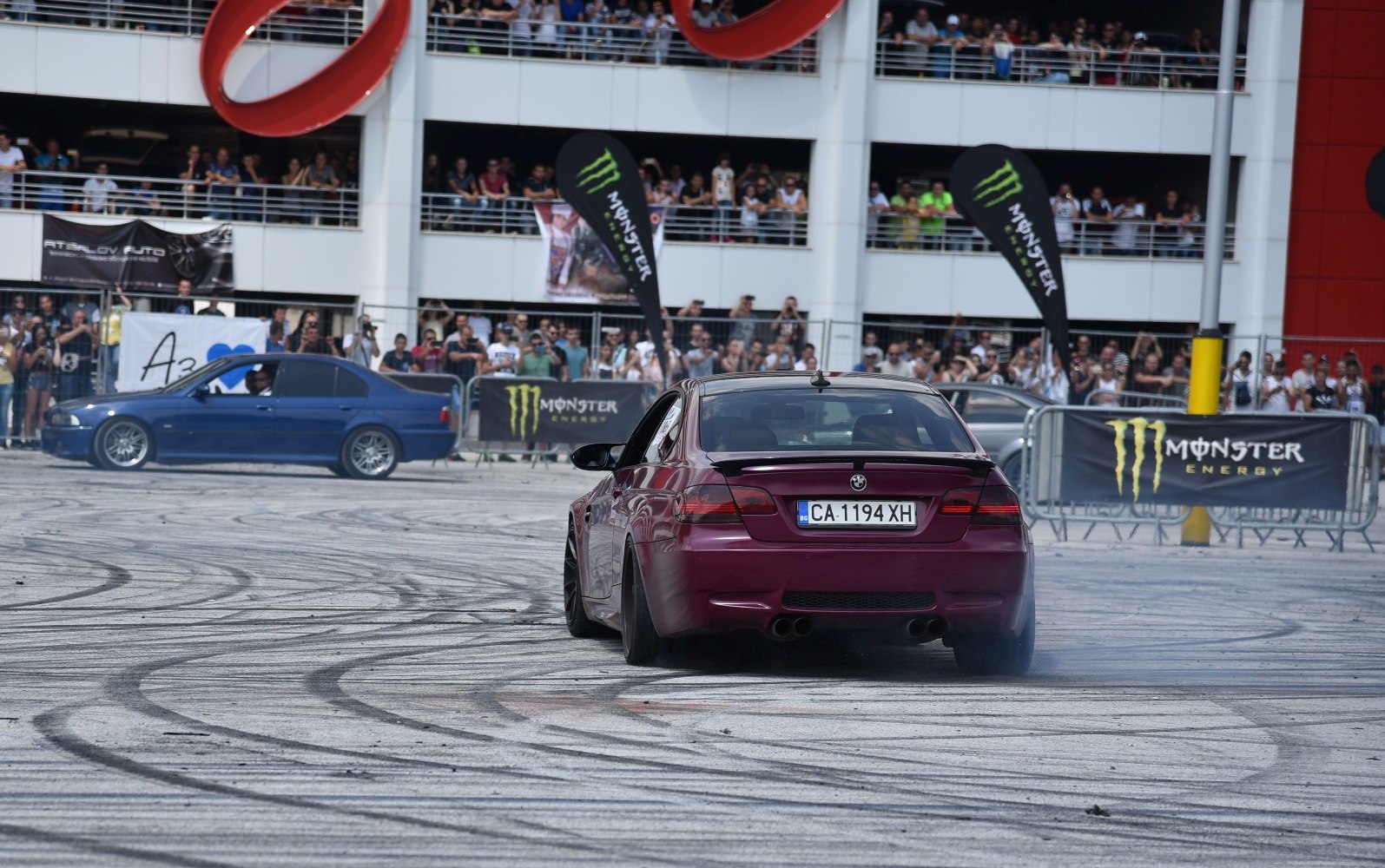 Rear view of a coupe drifting with smoky tire marks