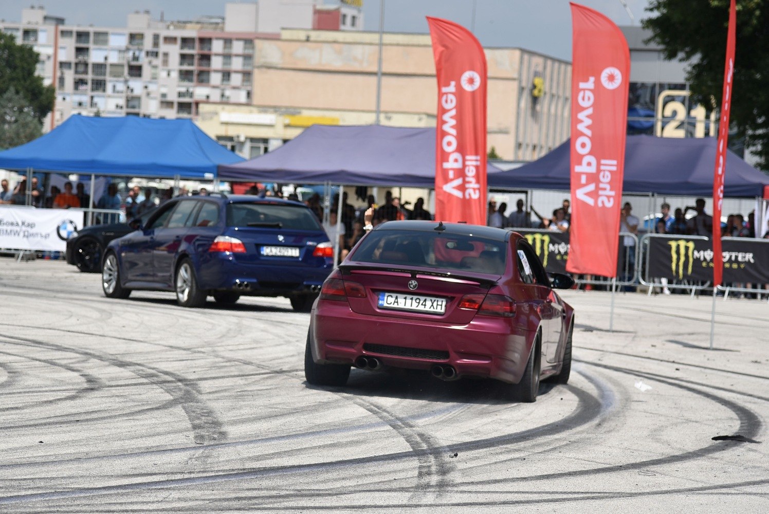 Rear of drifting coupe and station wagon on track with tire marks