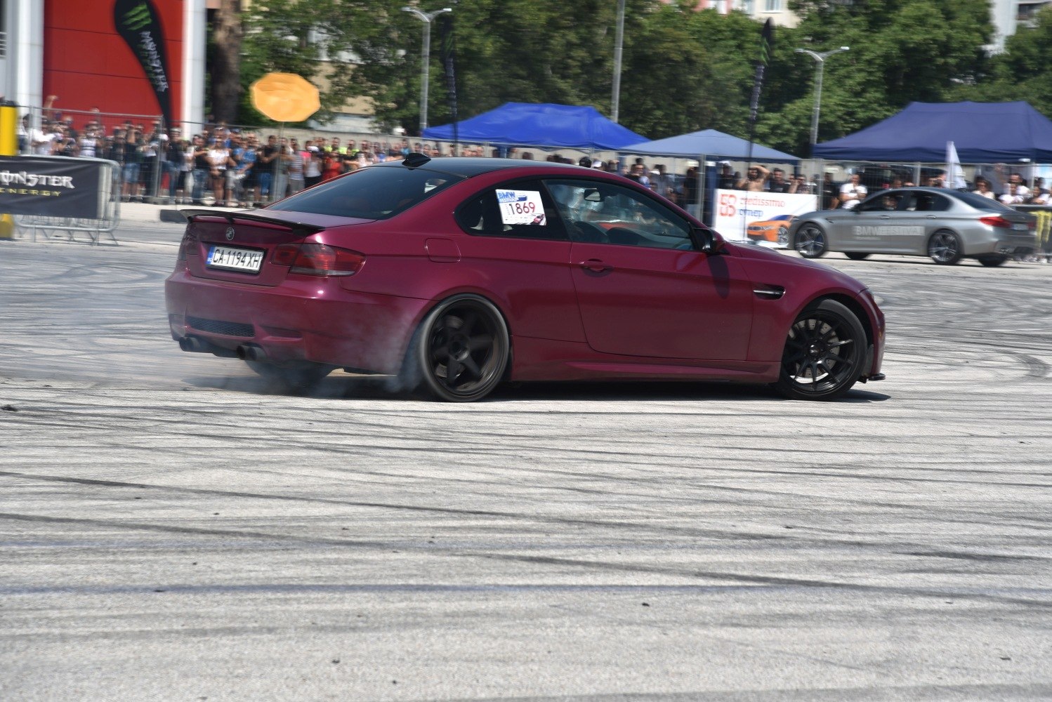 High-speed drifting with tire smoke by a sleek two-door coupe.