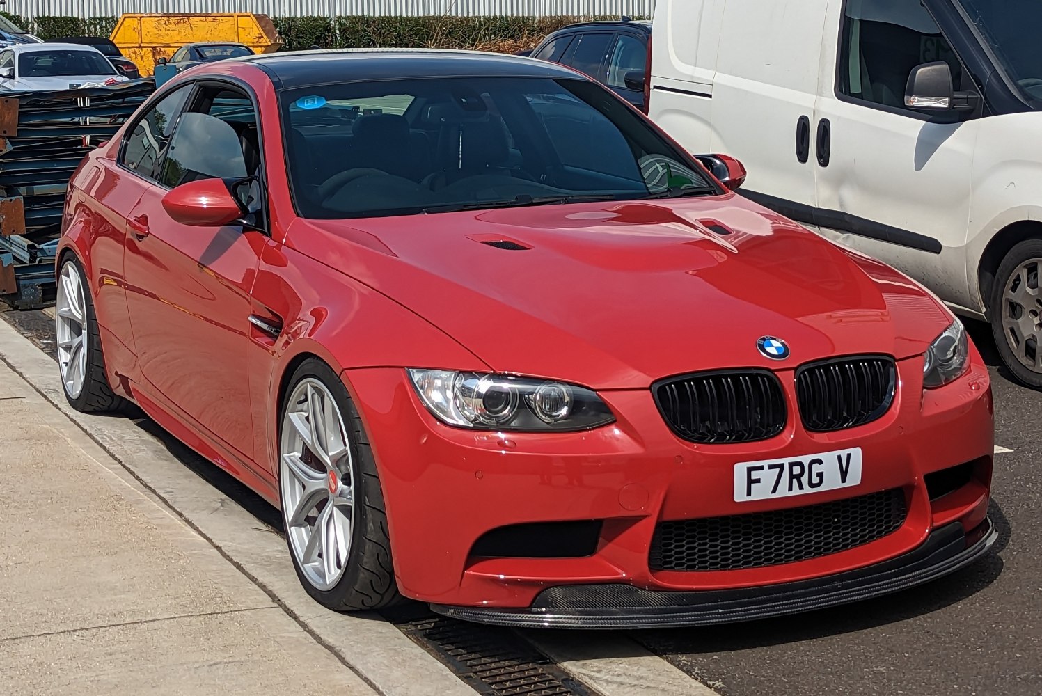 Sporty red coupe front with hood vents and wide silver alloy wheels