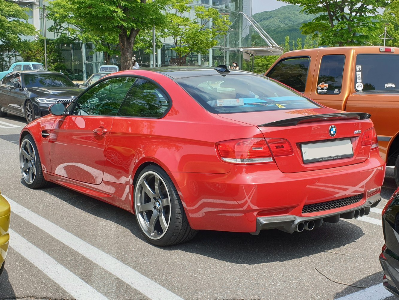 Sporty red coupe rear with quad exhausts and dark alloy wheels