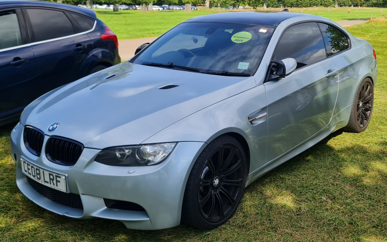 Silver coupe with black alloy wheels and front grille
