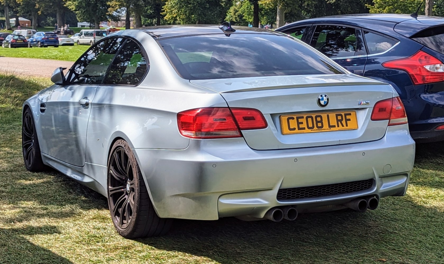 Silver coupe rear with quad exhaust and black sporty rims