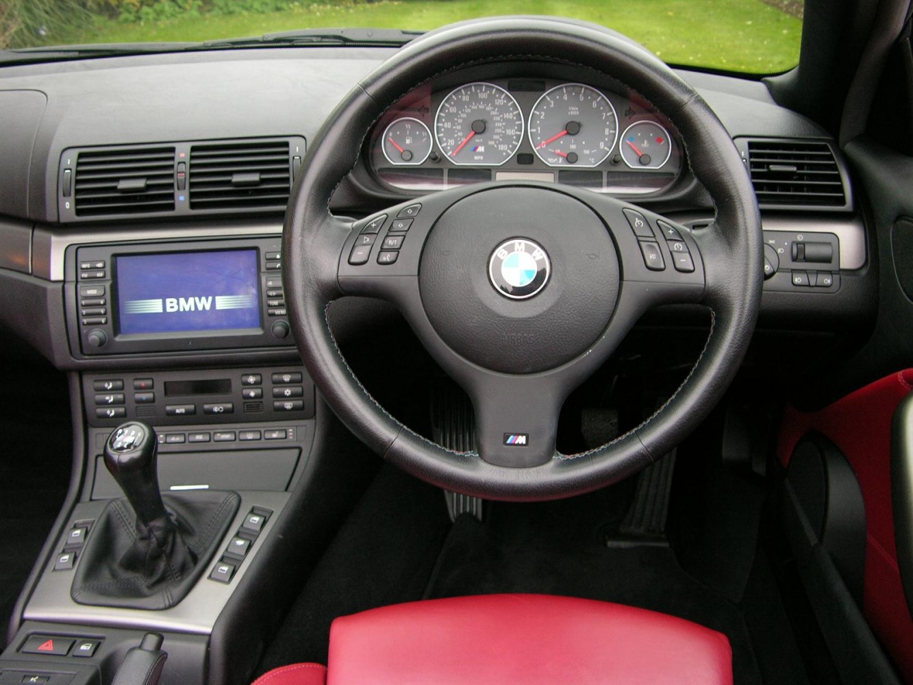 Leather steering wheel and manual gear stick in car interior