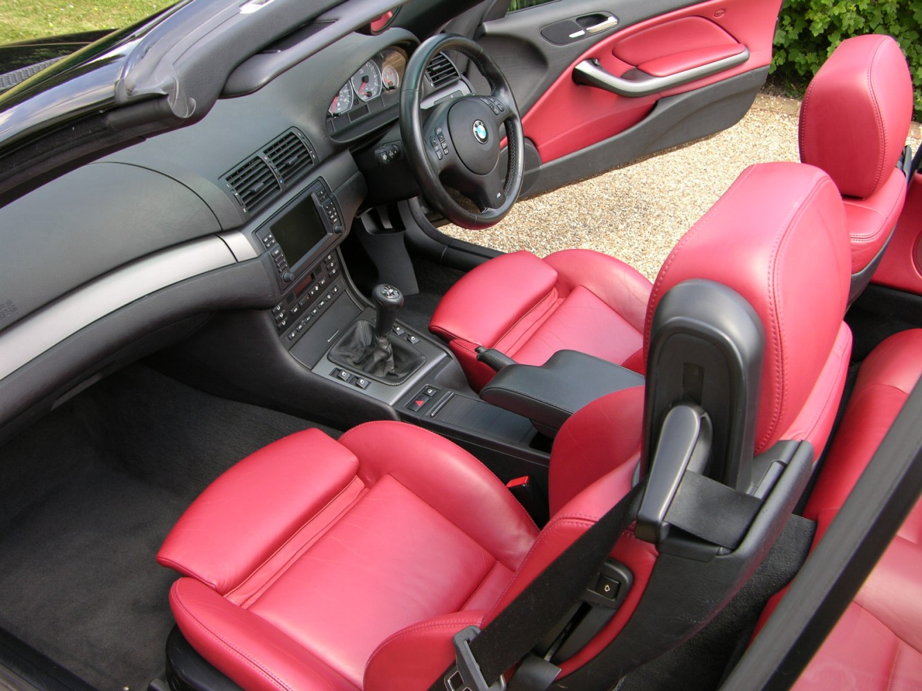 Red leather seats and manual transmission in a convertible interior