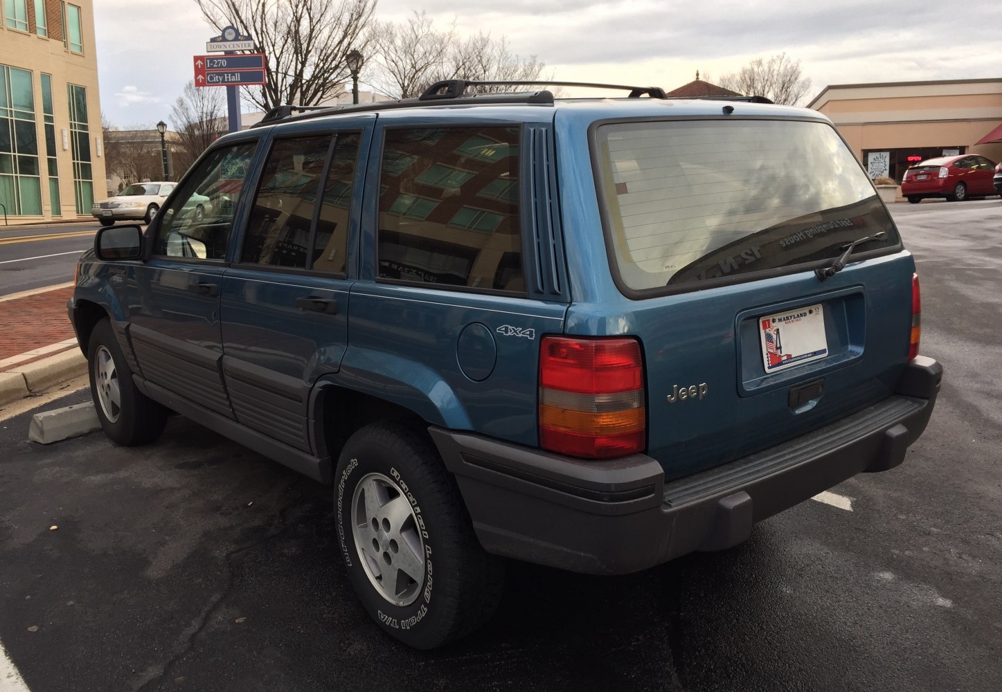 Rear side view of SUV with 4x4 badge and roof rack